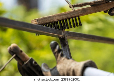 Welder cleans the welding surface using wire brush to remove residue flux and slug - Powered by Shutterstock