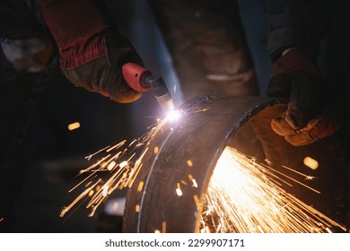 Welder cuts a metal pipe with a plasma cutter close up. - Powered by Shutterstock