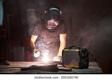 Welder In Helmet And Gloves At Work. Welding Light