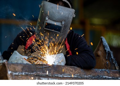 Welder in Iron mask helmet welds steel welding, Industrial worker at the factory welding steel structure, Welder is welding metalwork manufacturing and construction maintenance service.