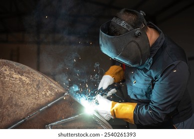 Welder is joining metal parts using a welding torch, creating sparks and wearing protective gear in an industrial setting - Powered by Shutterstock