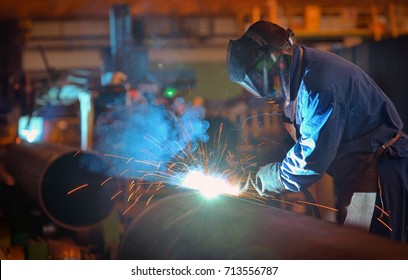 Welder performs welding large diameter pipe inside plant - Powered by Shutterstock