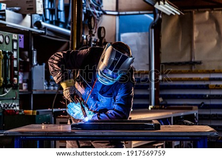 Similar – Image, Stock Photo Welder in protective helmet welding metal detail in workshop