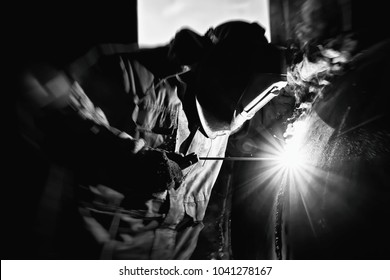 welder is repairing the defective area of the weld inside the parts of chemical apparatus