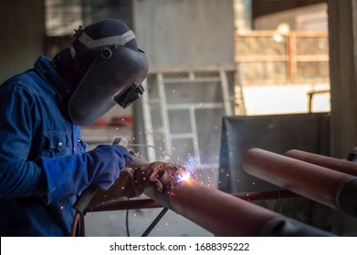 Welder wearing protective clothing for welding industrial construction oil and gas  at construction site .Welders with protective equipment welding outdoors pipeline construction.