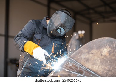 Welder wearing protective gear is joining metal parts using a welding torch, creating a shower of sparks - Powered by Shutterstock