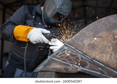 Welder wearing protective gear and using a mig mag welding torch is joining metal parts, creating a shower of sparks - Powered by Shutterstock - Get 15% off with code: PIKWIZARD15