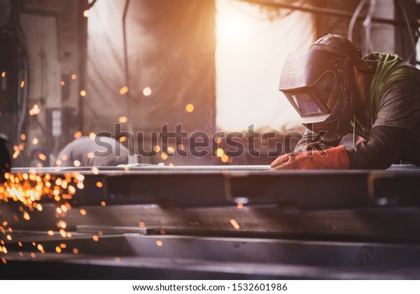 A welder\
with a welding machine works in a\
factory