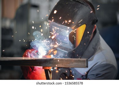 Welder is welding a metal frame.