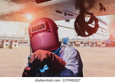 Welder Is Welding Process By Arc Worker With Spark Weld For Hull Ship Repairing Industrial, Wear Equipment Protective For Safety On Propeller Background.