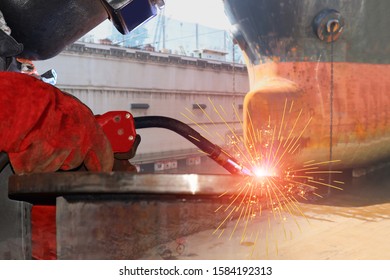 Welder Is Welding Process By MIG Torch With Spark Weld Factory At Shipbuilding And Ship Repairing Industrial, Wear Equipment Protective For Safety.