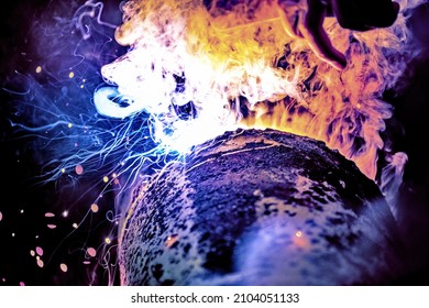 A welder welds metal into his workshop. Blue welding sparks. Gas combustion and blue smoke. Small welding workshop. Welding juncture of metal construction - Shutterstock ID 2104051133