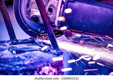 A welder welds metal into his workshop. Blue welding sparks. Gas combustion and blue smoke. Small welding workshop. Welding juncture of metal construction - Shutterstock ID 2104051151