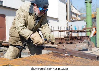 Welder worker during cutting works with propane oxygen gas blow torch burner with bunsen flame outdoor - Powered by Shutterstock