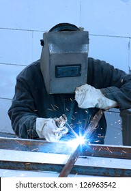 welder worker welding metal. Bright electric arc and sparks