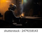 welder works with an electrode to produce a custom part. welding with sparks