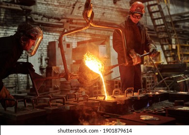 The welder works in the factory shop two steel workers melting metal