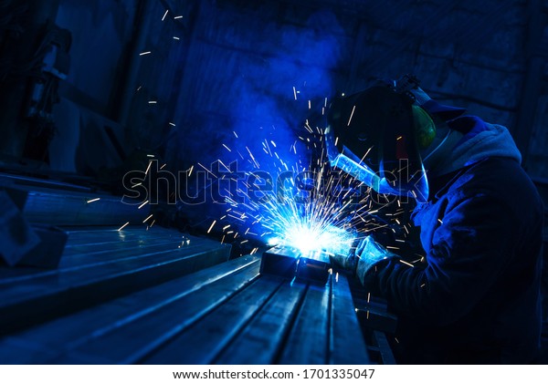 The welder works with a metal\
profile. Assembly of metal structures in industrial\
production