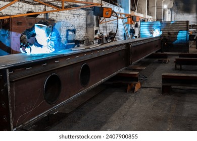 The welder works in the workshop. The moment of welding of metal structures. Beautiful sparks during welding of various metal elements in the workshop. The welder is working hard. - Powered by Shutterstock