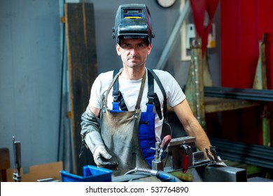 welder in workwear looking in to the camera