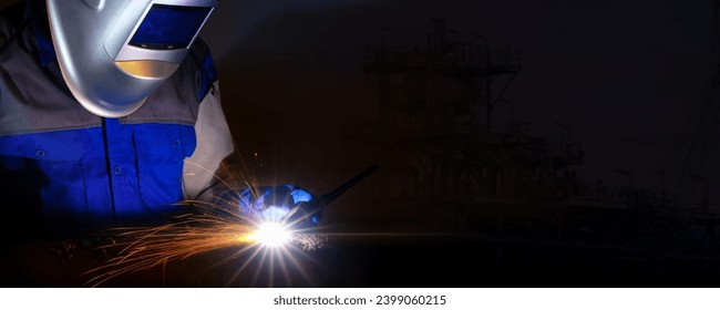 Welder-Worker welding and cutting steel in workshop of construction site with Oxy-Propane cutting and welding to steel part by manual. Banner Size with Copy Space. - Powered by Shutterstock