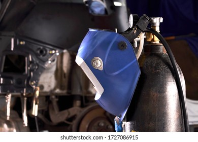 Welding Equipment In A Car Repair Station, Helmet Hanging On A Gas Tank, No People