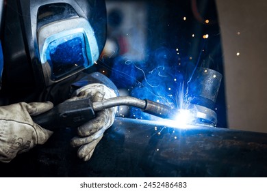 Welding, fabrication, manufacturing industry worker wearing personal protective equipment - Powered by Shutterstock