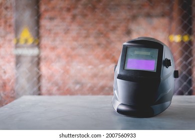 Welding Helmet Close Up On The Metal Workbench Background. Front View.