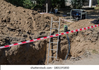 Welding Machine, Generator And Ladder Next To The Dug Trench. The Place Of The Repair Work Is Fenced Off With Prohibitive Fences. Safety. Emergency Pipeline Repair