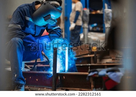 Welding male worker metal steel is part of beam structure plate construction.