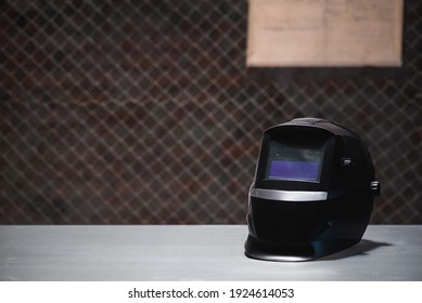 Welding Mask On The Metal Workbench Background.