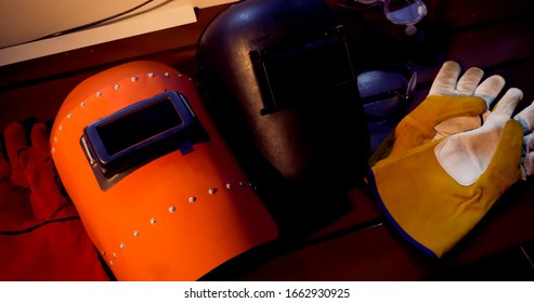 Welding Masks And Gloves On Wooden Table Background.