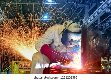 Welding Metal Steel Pipe In Factory With Light Spark On Night Shift Wear Equipment Protective PPE For Safety