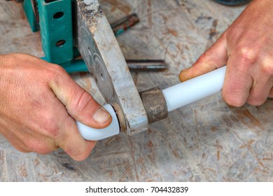 Welding of plastic pipes by melting using a plastic pipe welding machine, hands working closeup.