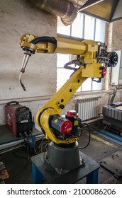 A Welding Robot In A Production Room Of A Mechanical Plant. The Picture Was Taken In Russia