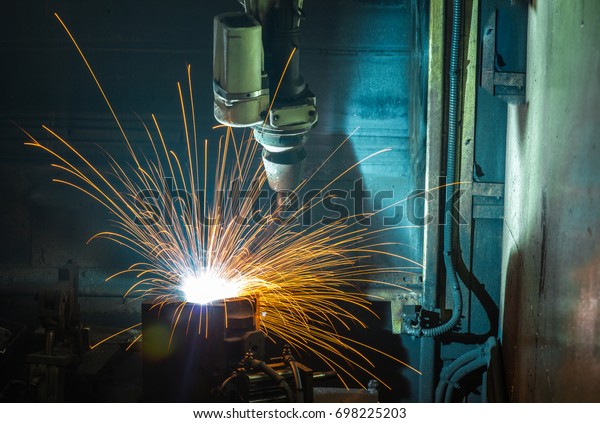 Welding robots in a car factory with sparks,\
manufacturing, industry