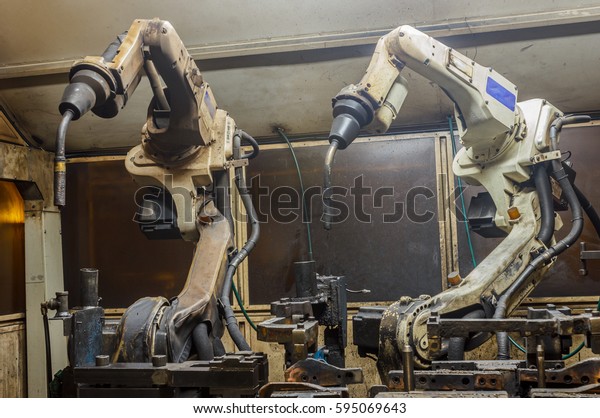 Welding robots machine in a car factory,\
manufacturing, industry