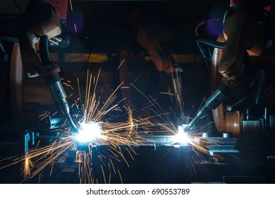 Welding robots movement in a car factory - Shutterstock ID 690553789