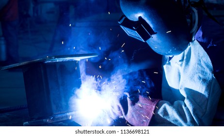 Welding with sparks by Process fluxed cored arc welding ,Industrial steel part in factory, dark tone, Selective focus. - Shutterstock ID 1136698121