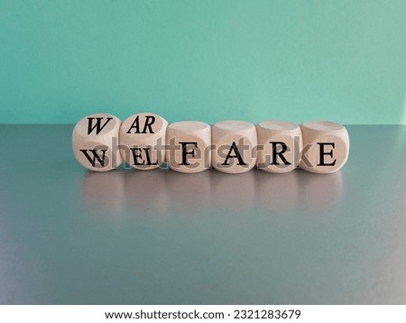 Welfare instead of warfare. Turned dices and changes the word war fare to wel fare. Beautiful blue background, grey table, copy space.