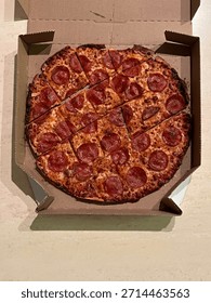 A well cooked pizza in a box