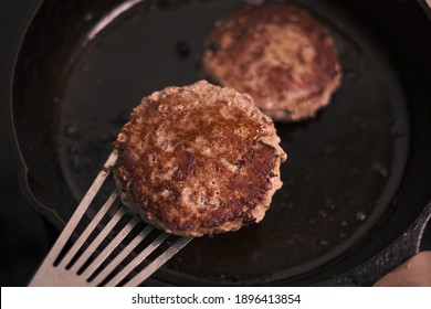 Well Crusted Hamburger Patties Sizzling In A Cast Iron Skillet. 