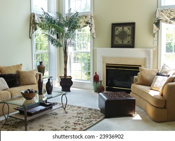 A Well Decorated Family Room In A Modern American Home With An Overstuffed Sofa, Chair And Glass Coffee Table. Large Windows Make The Room Very Bright And Airy.