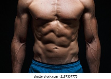 Well defined muscles due to working out to develop musculature in a strong athletic man at his abdomen or belly, chest and arms showing great abs - Powered by Shutterstock