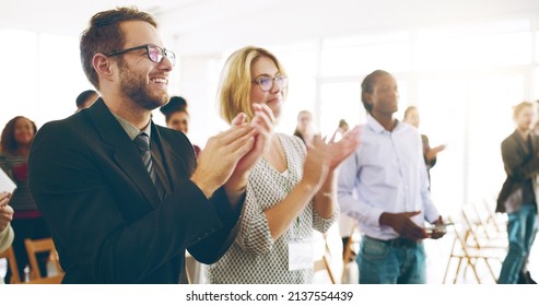 Well done. Cropped shot of a group of corporate businesspeople applauding during an award ceremony. - Powered by Shutterstock