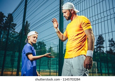 Well done. Serious bearded man giving high five orderly child. They wearing sports clothes and locating on court - Powered by Shutterstock