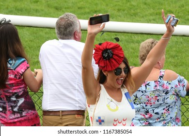 Well Dressed Woman Celebrates By Putting Arms In The Air After Cheering Home The Winner Of Horse Race At Thirsk Races : Thirsk Racecourse, Thirsk, Nth Yorkshire, UK : 3 August 2018 : Pic Mick Atkins