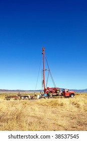 A Well Drilling Rig In An Empty Field.