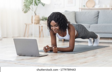 Well Fit Black Girl Planking At Living Room, Looking At Laptop Screen, Watching Online Fitness Lessons, Free Space