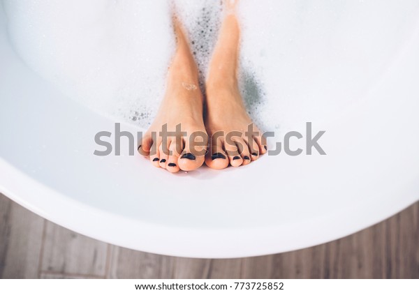 Well\
groomed woman\'s legs in bath foam close up\
image